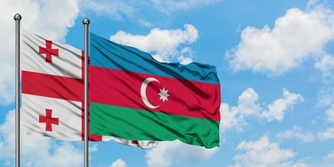 Georgia and Azerbaijan flag waving in the wind against white cloudy blue sky together. Diplomacy concept, international relations.