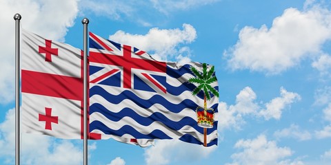 Georgia and British Indian Ocean Territory flag waving in the wind against white cloudy blue sky together. Diplomacy concept, international relations.