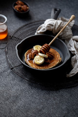Pancakes with banana, walnuts and honey. Morning concept
