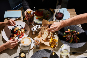 cropped view of people eating delicious food in restaurant