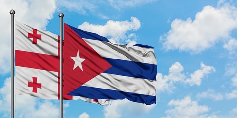 Georgia and Cuba flag waving in the wind against white cloudy blue sky together. Diplomacy concept, international relations.