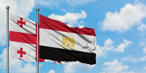 Georgia and Egypt flag waving in the wind against white cloudy blue sky together. Diplomacy concept, international relations.