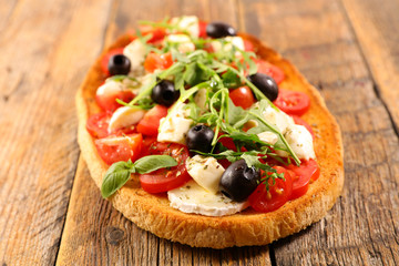 Fototapeta na wymiar bruschetta with cheese, tomato, olive and rocket