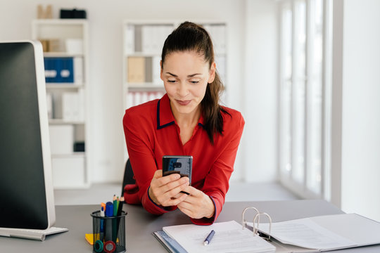 Attractive businesswoman checking her mobile