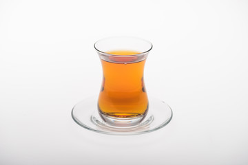 glass cup of tea on saucer isolated on white