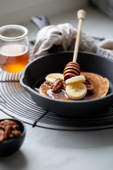 Pancakes with banana, walnuts and honey. Morning concept