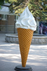 Large mockup of ice cream in a waffle cone in a summer park.
