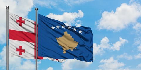 Georgia and Kosovo flag waving in the wind against white cloudy blue sky together. Diplomacy concept, international relations.