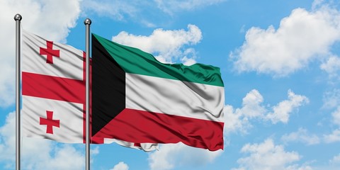 Georgia and Kuwait flag waving in the wind against white cloudy blue sky together. Diplomacy concept, international relations.