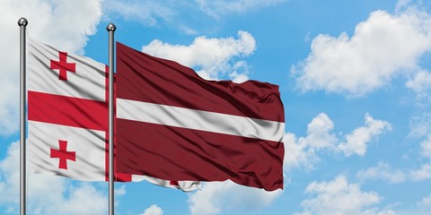 Georgia and Latvia flag waving in the wind against white cloudy blue sky together. Diplomacy concept, international relations.