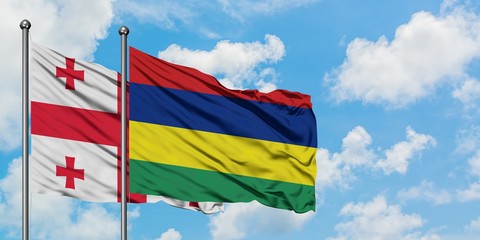 Georgia and Mauritius flag waving in the wind against white cloudy blue sky together. Diplomacy concept, international relations.