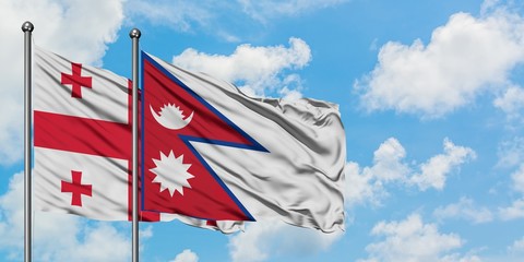 Georgia and Nepal flag waving in the wind against white cloudy blue sky together. Diplomacy concept, international relations.