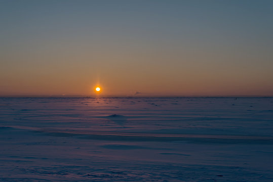 colorful sunset over the expanse of the snowy North sea © Valerii Ivanov