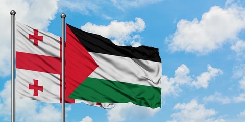 Georgia and Palestine flag waving in the wind against white cloudy blue sky together. Diplomacy concept, international relations.