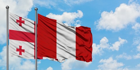 Georgia and Peru flag waving in the wind against white cloudy blue sky together. Diplomacy concept, international relations.