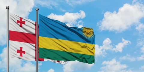 Georgia and Rwanda flag waving in the wind against white cloudy blue sky together. Diplomacy concept, international relations.