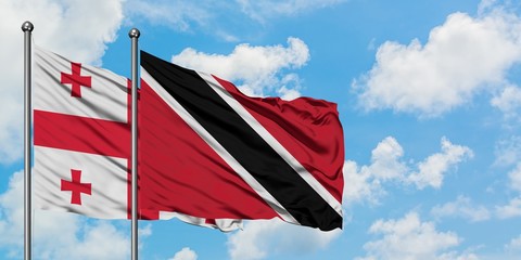 Georgia and Trinidad And Tobago flag waving in the wind against white cloudy blue sky together. Diplomacy concept, international relations.