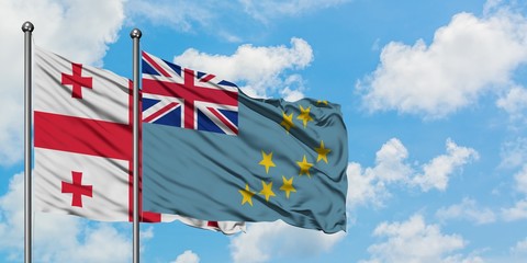 Georgia and Tuvalu flag waving in the wind against white cloudy blue sky together. Diplomacy concept, international relations.