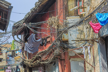 Electric wires and laundry in an alley in the old city neighborhood of Shanghai