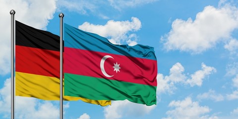Germany and Azerbaijan flag waving in the wind against white cloudy blue sky together. Diplomacy concept, international relations.