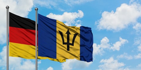 Germany and Barbados flag waving in the wind against white cloudy blue sky together. Diplomacy concept, international relations.
