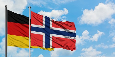 Germany and Bouvet Islands flag waving in the wind against white cloudy blue sky together. Diplomacy concept, international relations.