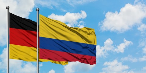 Germany and Colombia flag waving in the wind against white cloudy blue sky together. Diplomacy concept, international relations.
