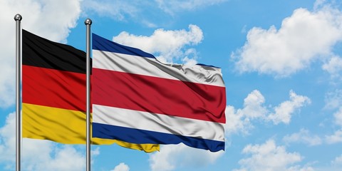 Germany and Costa Rica flag waving in the wind against white cloudy blue sky together. Diplomacy concept, international relations.
