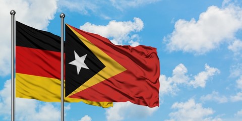 Germany and East Timor flag waving in the wind against white cloudy blue sky together. Diplomacy concept, international relations.