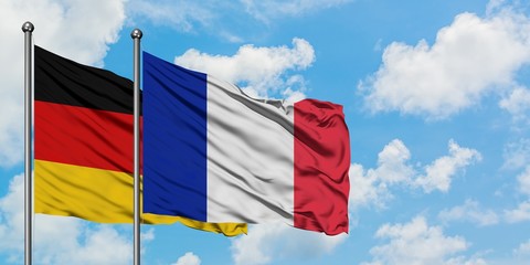 Germany and France flag waving in the wind against white cloudy blue sky together. Diplomacy concept, international relations.