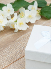 Gift box with jasmine flowers on the background.