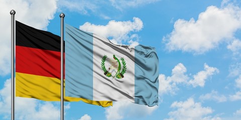 Germany and Guatemala flag waving in the wind against white cloudy blue sky together. Diplomacy concept, international relations.