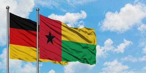 Germany and Guinea Bissau flag waving in the wind against white cloudy blue sky together. Diplomacy concept, international relations.