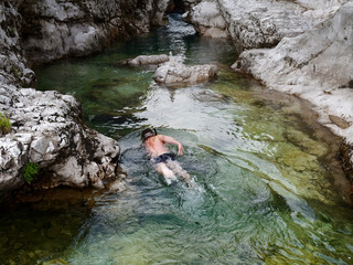 Fototapeta na wymiar a man swims in a mountain river. Italy