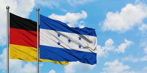 Germany and Honduras flag waving in the wind against white cloudy blue sky together. Diplomacy concept, international relations.