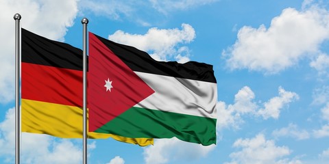 Germany and Jordan flag waving in the wind against white cloudy blue sky together. Diplomacy concept, international relations.