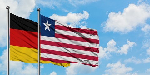 Germany and Liberia flag waving in the wind against white cloudy blue sky together. Diplomacy concept, international relations.