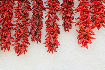 pimientos rojos colgados a secar sobre una pared blanca almería U84A0797-as19