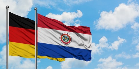 Germany and Paraguay flag waving in the wind against white cloudy blue sky together. Diplomacy concept, international relations.