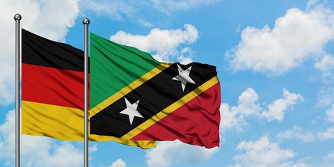 Germany and Saint Kitts And Nevis flag waving in the wind against white cloudy blue sky together. Diplomacy concept, international relations.