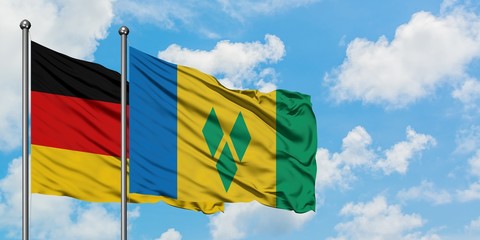 Germany and Saint Vincent And The Grenadines flag waving in the wind against white cloudy blue sky together. Diplomacy concept, international relations.