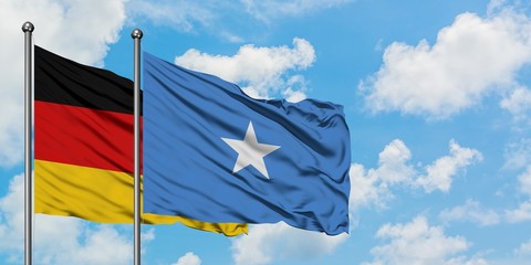 Germany and Somalia flag waving in the wind against white cloudy blue sky together. Diplomacy concept, international relations.