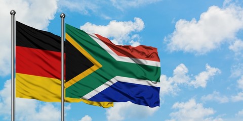 Germany and South Africa flag waving in the wind against white cloudy blue sky together. Diplomacy concept, international relations.