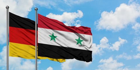 Germany and Syria flag waving in the wind against white cloudy blue sky together. Diplomacy concept, international relations.