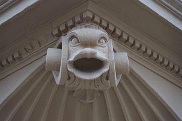 Fischskulptur mit offenem Mund als Fassadenverzierung eines alten Gebäudes