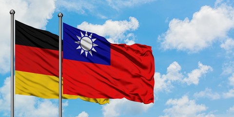 Germany and Taiwan flag waving in the wind against white cloudy blue sky together. Diplomacy concept, international relations.