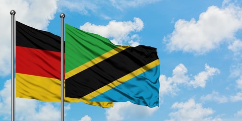 Germany and Tanzania flag waving in the wind against white cloudy blue sky together. Diplomacy concept, international relations.