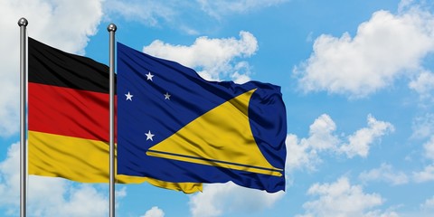 Germany and Tokelau flag waving in the wind against white cloudy blue sky together. Diplomacy concept, international relations.