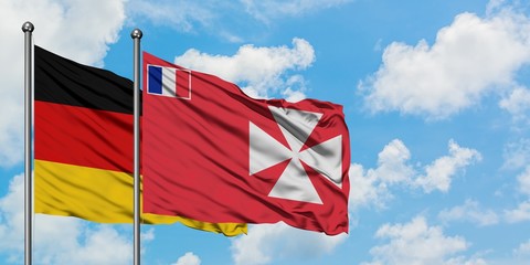 Germany and Wallis And Futuna flag waving in the wind against white cloudy blue sky together. Diplomacy concept, international relations.
