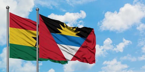 Ghana and Antigua and Barbuda flag waving in the wind against white cloudy blue sky together. Diplomacy concept, international relations.